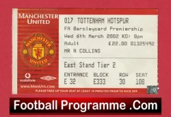 Ticket stub for a Manchester United vs Tottenham Hotspur football match, featuring the Manchester United crest on a red background with seating details and match info visible the bottom area shows a black 'Football Programme .Com' bar.