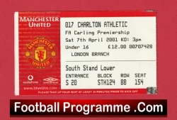 Close-up of a red Manchester United football programme cover with a match ticket stub, showing the club crest and seating details, and 'Football Programme .Com' text on the bottom.
