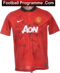 Red Manchester United football jersey autographed by multiple players, featuring the Aon sponsor logo and club crest.