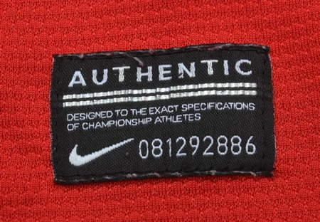 Close-up of an authentic label on red fabric showing the Nike swoosh and serial number 081292886.