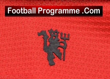 Football Programme .Com logo on red textured fabric; black devil mascot centered beneath a white-on-black banner.