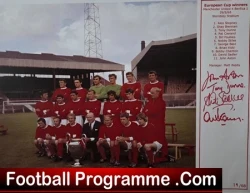 Team photo of a red-clad football squad on the cover of FootballProgramme.com, with a signatures panel on the right.