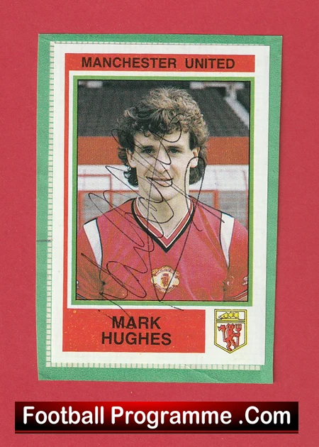 Autographed Manchester United trading card featuring Mark Hughes in a red jersey with club crest, mounted on green and red backdrop.