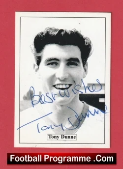 Black-and-white portrait of Tony Dunne with a blue autograph across the image, mounted on a red border.