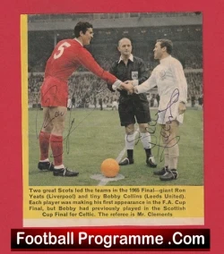 Football programme cover: two players shake hands on a pitch with a referee between them; red kit on left, white kit on right.