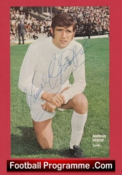 Autographed vintage football programme cover featuring a kneeling player in a white kit on a grassy pitch with a red border.